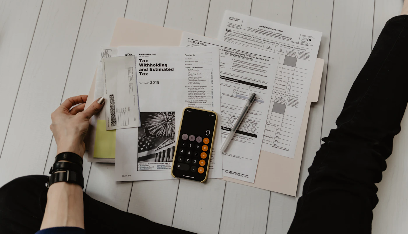Documente fiscale și un calculator, fotografiate de sus